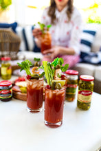Load image into Gallery viewer, Two Bloody Marys with a woman and Mezzetta jars
