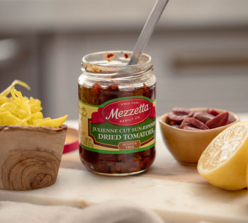 Jar of Mezzetta Julienne Cut Sun-Ripened Dried Tomatoes with peperoncini, Kalamata olives, and lemon