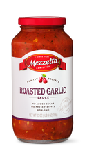 Load image into Gallery viewer, A clear glass jar of Mezzeta Family Co. Roasted Garlic Sauce against a black background. The sauce is red with visible herbs and spices.