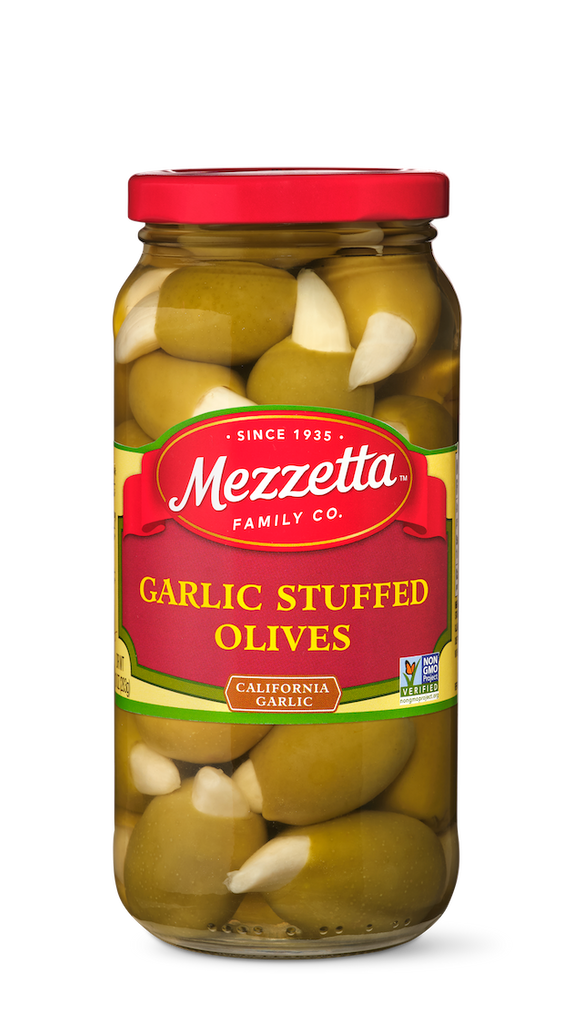 A glass jar filled with Mezzetta Garlic Stuffed Olives. The jar displays the Mezzetta Family Co. branding and a