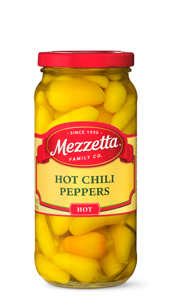 A glass jar displays vibrant yellow, pickled hot chili peppers from Mezzetta Family Co.
