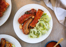 Load image into Gallery viewer, A plate with three Italian Pork Ribs served with a side of fennel slaw
