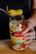Load image into Gallery viewer, Woman grabbing a peperoncini out of a jar of Mezzetta Giardiniera 
