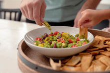 Load image into Gallery viewer, Hands dipping pita chips into guacamole 
