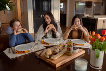 Load image into Gallery viewer, Mom and two kids biting into a sandwich
