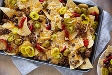 Load image into Gallery viewer, A sheet pan covered in loaded nachoes
