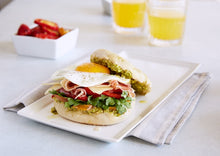 Load image into Gallery viewer, Mezzetta Breakfast Sandwich served in a white plate with two glasses of orange juice
