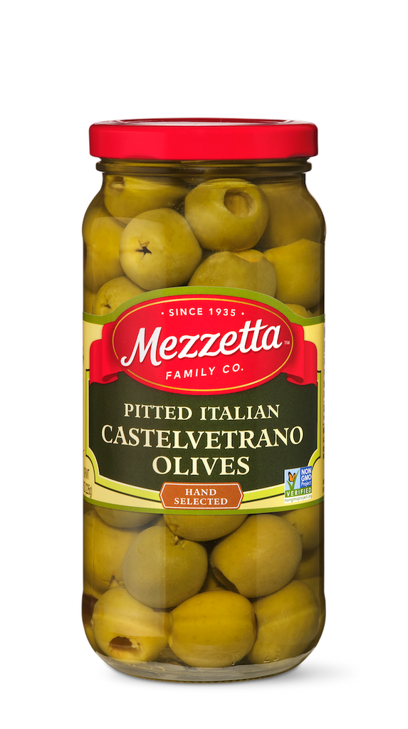 A glass jar filled with bright green, hand-selected, pitted Castelvetrano olives from Mezzetta Family Co.