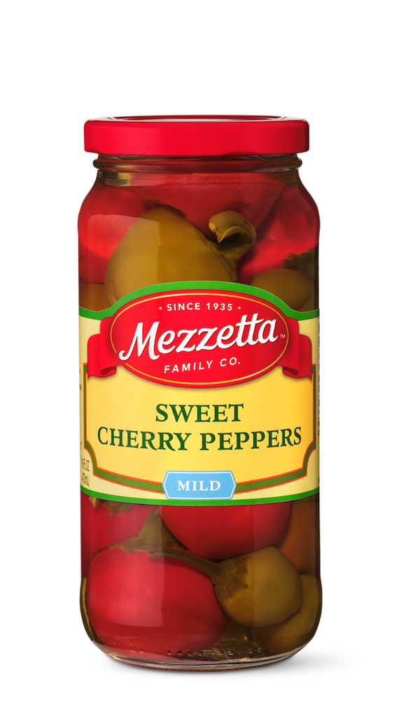 A glass jar displays whole, mild, sweet cherry peppers from Mezzetta Family Co., perfect for adding a burst of flavor to any dish.