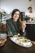 Load image into Gallery viewer, Woman smiling while holding a green olive with a antipasto platter in front of her
