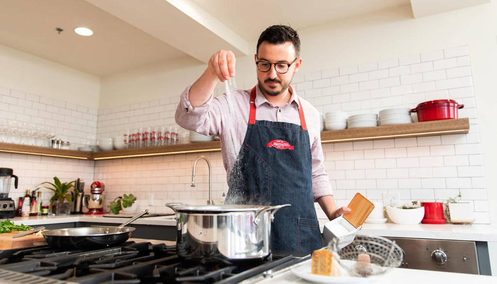 Chef Andrew adding salt to a pot of water