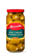 A glass jar filled with hand-selected green olives stuffed with creamy blue cheese from Mezzetta Family Co. 
