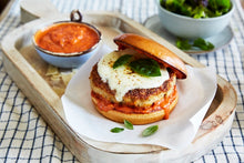 Load image into Gallery viewer, Chicken Parmesan Burger on a wooden platter with a side of Mezzetta Marinara sauce
