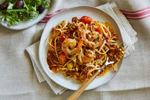 Load image into Gallery viewer, A plate of Garlic Shrimp Linguine with a side salad on a linen table coth
