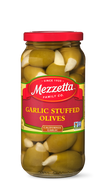 A glass jar filled with Mezzetta Garlic Stuffed Olives. The jar displays the Mezzetta Family Co. branding and a 