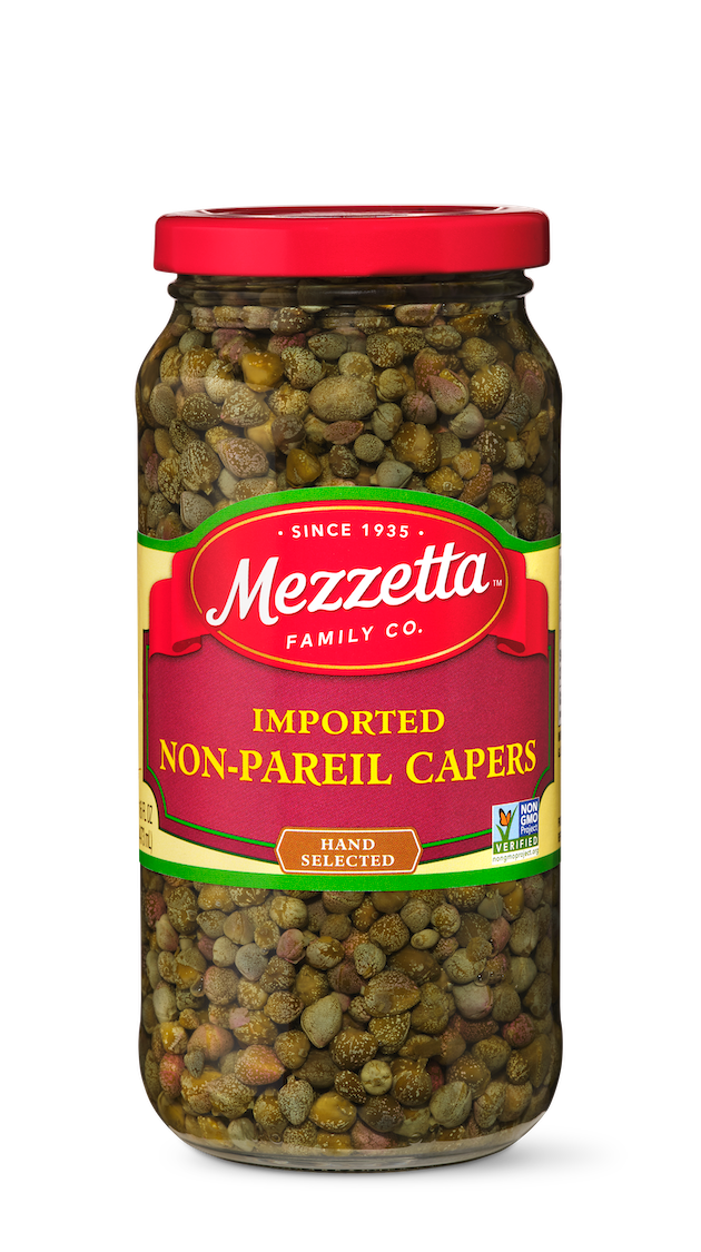 A clear glass jar overflows with hand-selected, non-pareil capers from Mezzetta Family Co., perfect for adding a burst of briny flavor to any dish. 
