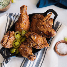 Load image into Gallery viewer, A skillet of fried chicken topped with jalapeno slices
