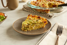 Load image into Gallery viewer, A slice of Olive and Artichoke Quiche on a grey plate
