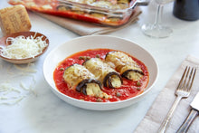 Load image into Gallery viewer, Three Spicy Eggplant Rollatini with a side of cheese and utensils 
