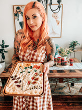 Load image into Gallery viewer, Woman holding focaccia bread topped with Mezzetta products shaped into a flower.
